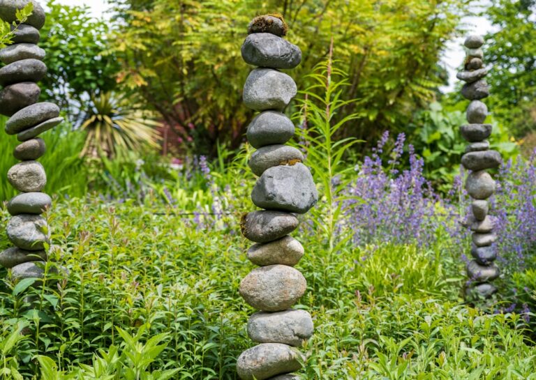 A family arranges river rocks and gravel around a backyard garden bed filled with perennials.
