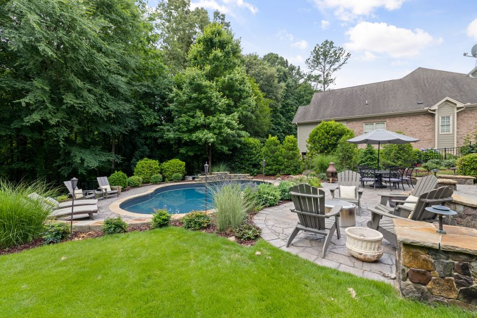 A backyard garden with blooming native flowers, a birdbath, and butterflies resting on blossoms.